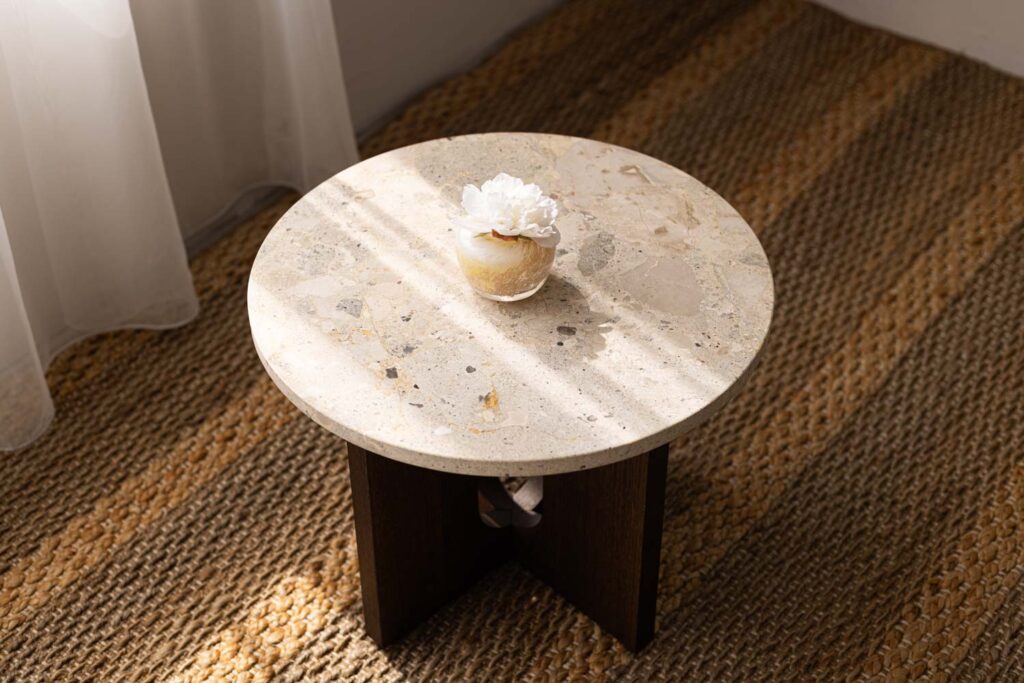 大理石調の丸テーブル上に、白い花のディフューザーが置かれている写真