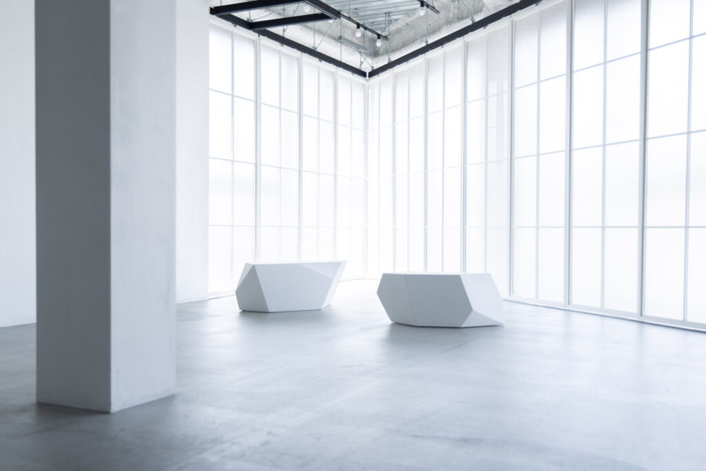 白い多角形の椅子が2つ白い窓枠の前に並んでいる写真