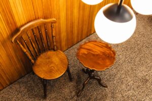 暖色系の照明で照らされた、木製椅子とテーブルを俯瞰から捉えた写真