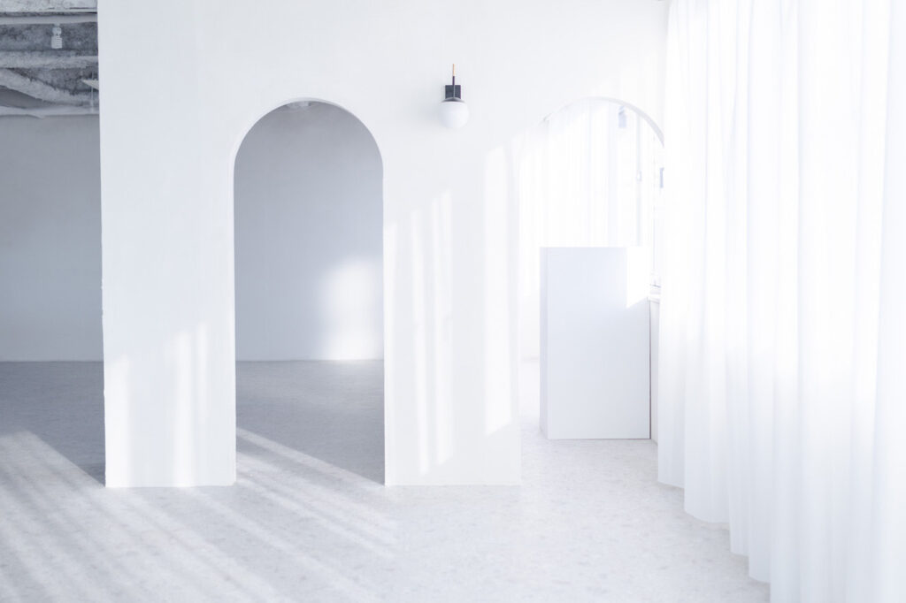 アーチ壁が2つあり、柔らかな自然光が入る白基調の空間
