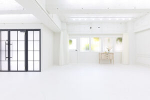 柔らかい自然光が入る、白基調の広いスタジオの写真