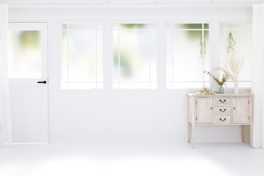 アンティーク窓から柔らかな光が入る白基調の空間