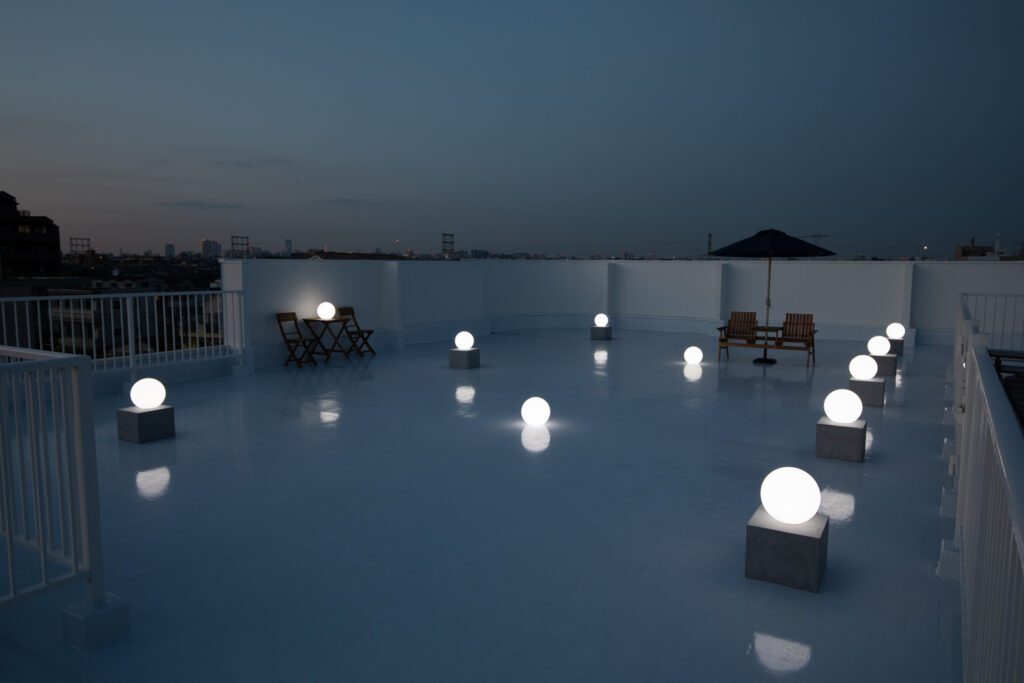 夕暮れの屋上で、ライティングボールが白く光る写真