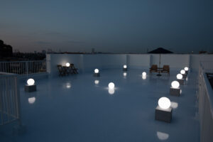 夕暮れの屋上で、ライティングボールが白く光る写真