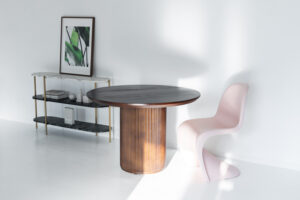 木製の丸テーブルとピンクのヴィトラチェアが並ぶ写真